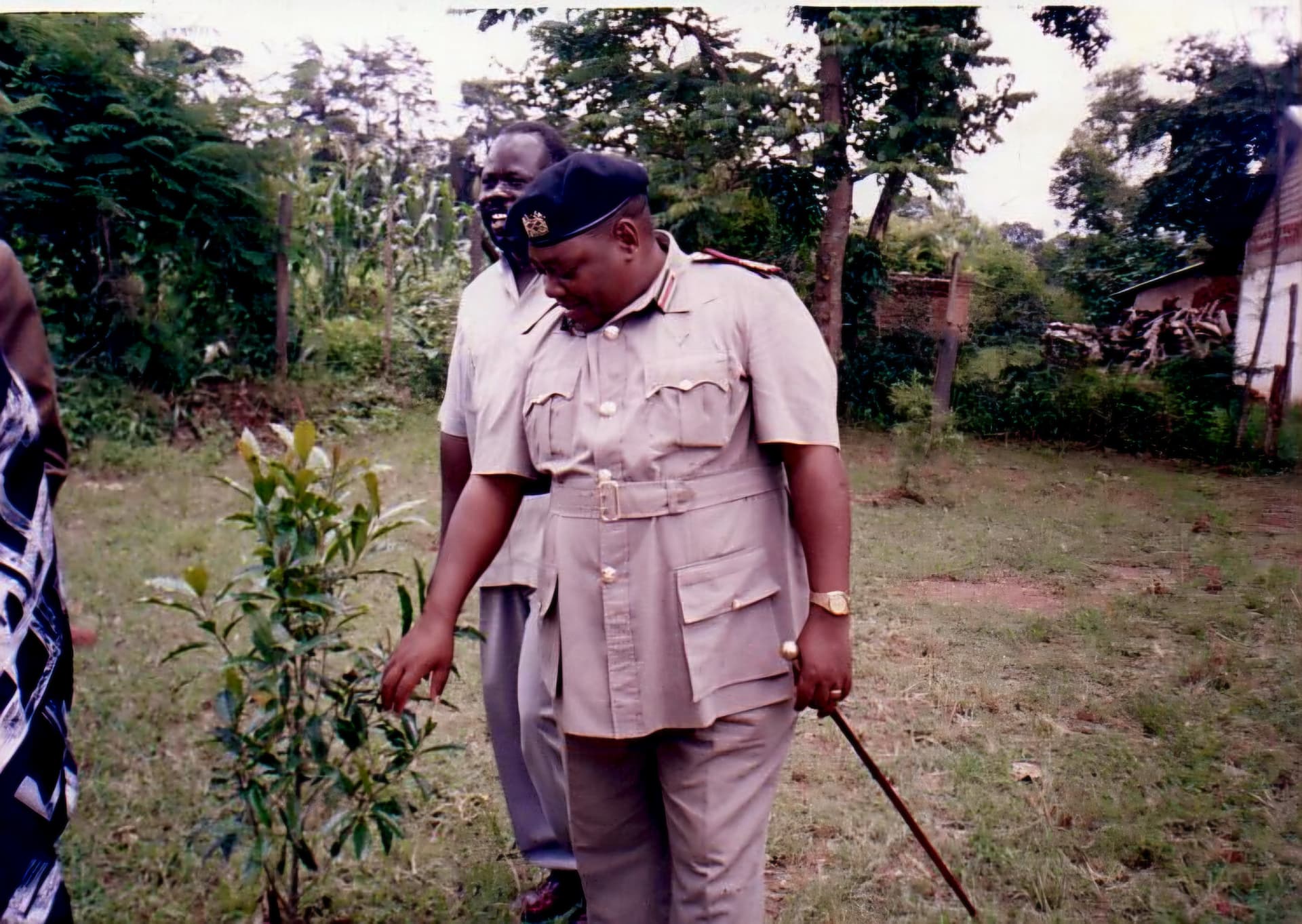 An administration officer in uniform inspecting a young tree