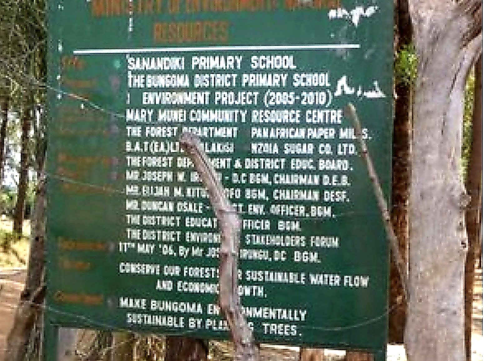 Green signboard describing the Bungoma District Primary School Environment Project at Sanandiki Primary School