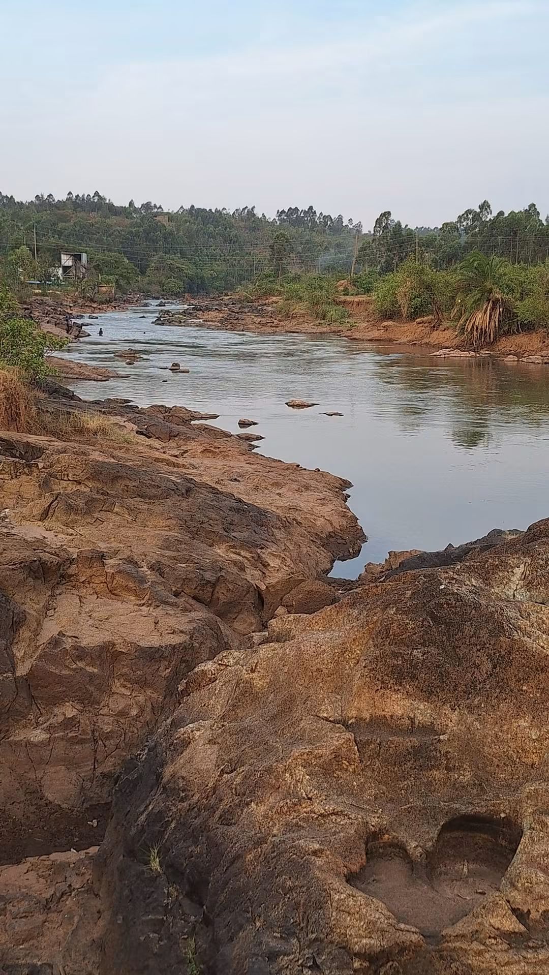 River Nzoia at Webuye on the Bungoma/Kakamega boundary in dry season, showing exposed rocky banks and degraded riparian vegetation